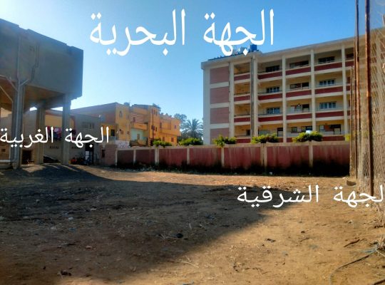 ملعب كرة قدم وقطعة ارض أمامه فاضية للمباني